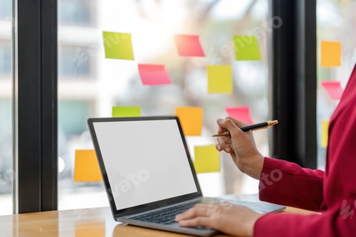 Preview: Cropped shot of woman hand working on laptop computer and peper work while sitting at the table