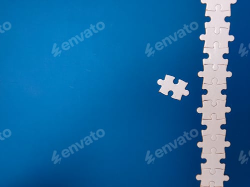 Preview: Unfinished white jigsaw puzzle pieces on blue background