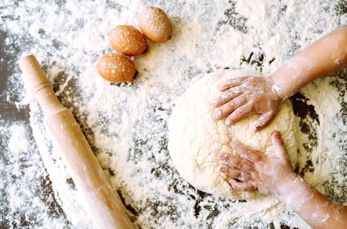 Preview: Children hands kneading dough on wooden table. Easter baking preparation. Cookies for Christmas.