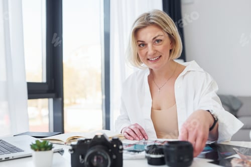 Preview: Middle-aged woman in elegant clothes is at home. Photographer with camera