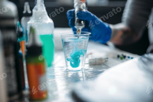 Preview: Female tattooer hands holds tattoo machine