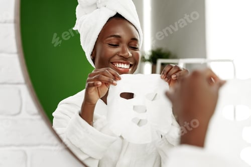 Preview: Woman applying a facial mask while smiling in a bathroom setting with a mirror reflection