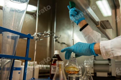Preview: a person holding a flask filled with liquid and chemicals