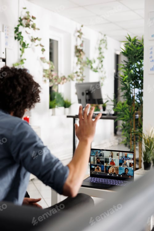 Preview: Executive greeting coworkers during video conference call on laptop