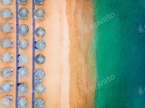 Preview: Aerial view of amazing beach with blue umbrellas and turquoise sea, Greece.