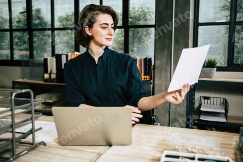 Preview: Business Woman Reviews Documents at Office Desk