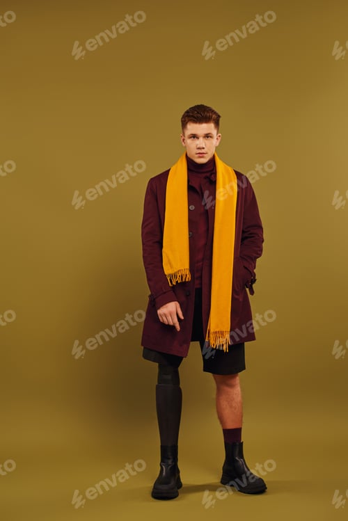 Preview: Stylish young man with prosthetic leg showcases trendy fashion in studio setting