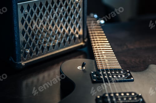 Preview: Close-up, black electric guitar on a dark background.