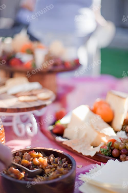 Preview: A table laid with a buffet selection of food dishes. Desserts and cheese board.