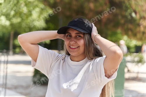 Preview: Young woman wearing visor and smiling in park