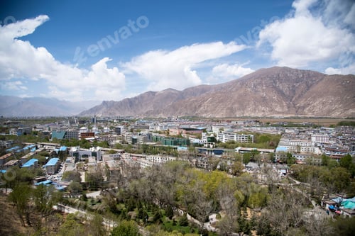 Preview: Idyllic valley surrounded by towering mountains with a view of Lhasa city