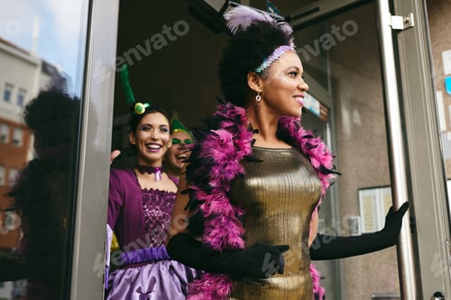 Preview: Happy black woman and her friends in carnival costumes going to Mardi Gras parade.