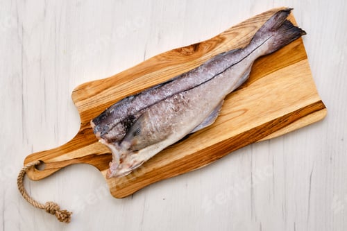 Preview: Top view of fresh haddock carcass on wooden cutting board