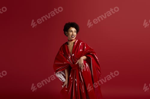 Preview: Elegant young woman showcasing stunning fashion against vibrant red backdrop