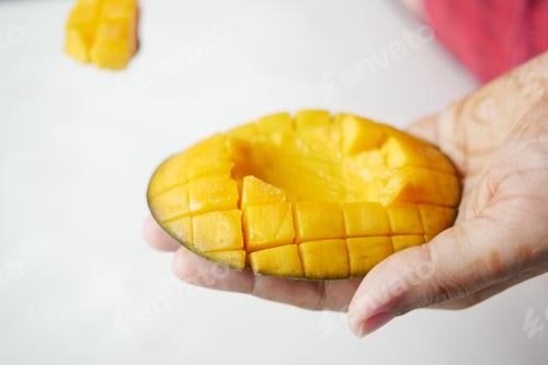Preview: young women eating slice of a mango