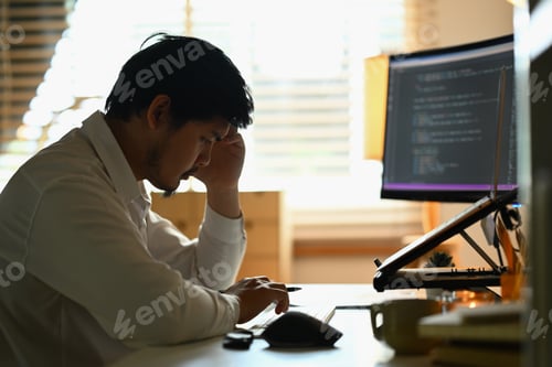Preview: Shot stressed male software developer programming code on computer screen