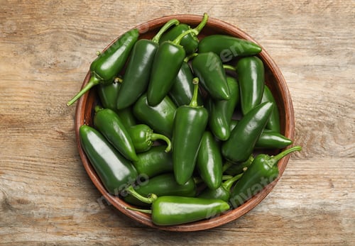 Preview: Bowl with green hot chili peppers on wooden table, top view