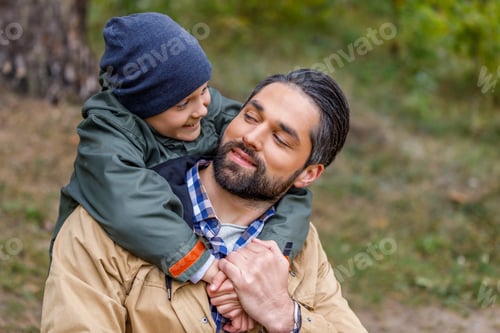 Preview: happy son hugging his smiling father