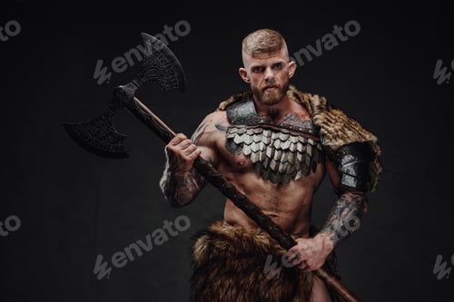 Preview: Brutal tattooed warrior wearing light armour and fur holding two-handed axe in dark studio