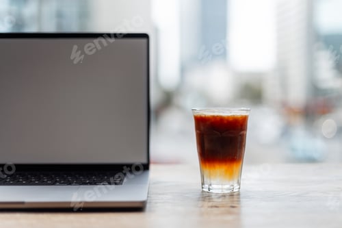 Preview: espresso stands on a wooden table with a mock up laptop