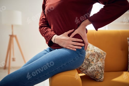 Preview: Woman With Strong Hip Pain At Home.