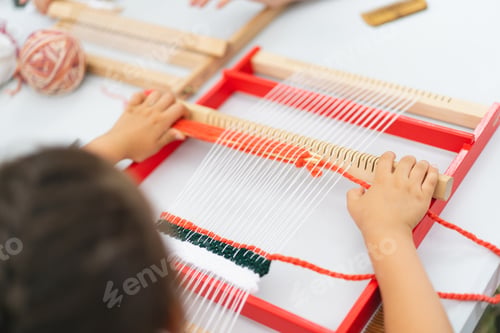 Preview: Girl weaving small rug with pattern at masterclass on weaving.