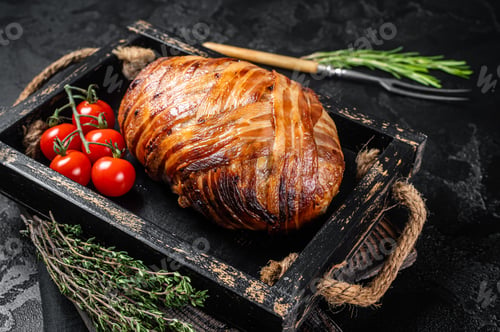 Preview: Roast bacon wrapped meatloaf, meat loaf in a tray with herbs. Black background. Top view