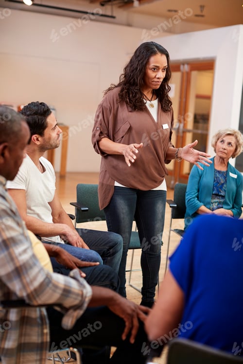 Preview: Woman Standing To Address Self Help Therapy Group Meeting In Community Center