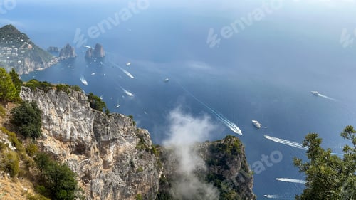 Preview: Sailing amidst picturesque rocky formations against a stunning sky backdrop in Capri, Italy