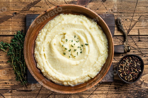 Preview: Mashed potatoes, boiled puree in a wooden plate. Wooden background. Top view