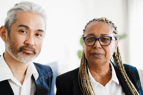 Preview: Multiracial business colleagues looking at camera inside modern office - Focus on african woman face