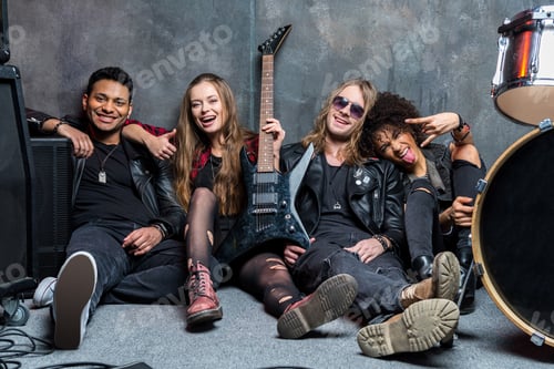 Preview: rock band sitting on floor while resting after rehearse in studio