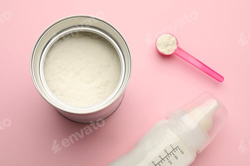 Preview: Feeding bottle with infant formula and powder on pink background, flat lay