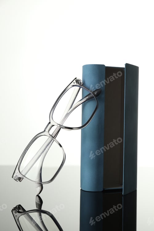 Preview: Elegant Eyeglasses Leaning on a Blue Book