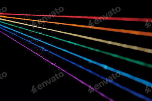 Preview: multicolored sewing threads in the form of a rainbow on a black background