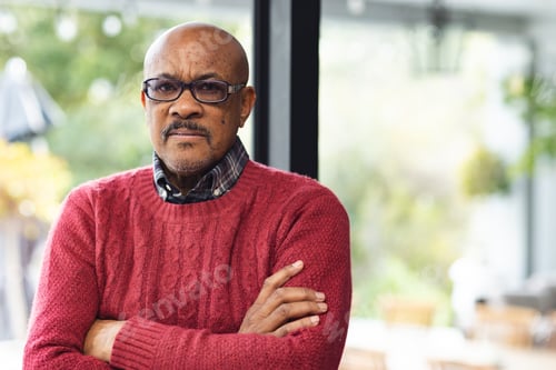 Preview: Portrait of senior biracial man wearing glasses crossing arms at home, copy space