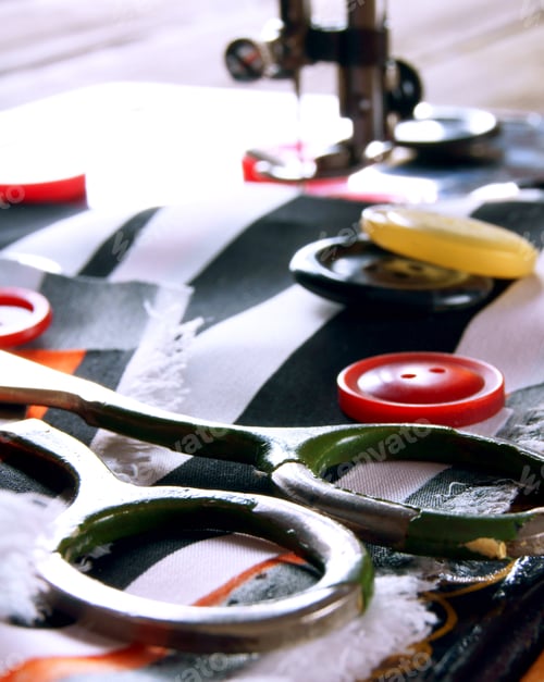 Sewing Machine, Buttons, and Scissors on Striped Fabric