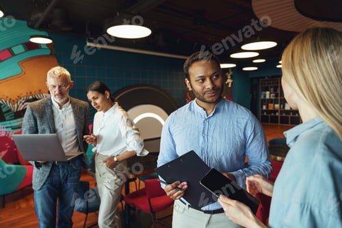 Preview: Group of diverse business people standing on office background and discuss work issues