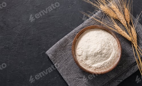 Preview: Wheat flour and dry branch on a dark background. Organic baking ingredients.