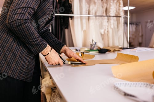 Preview: Tailor working at studio cutting fabric, detail of hand with scissors