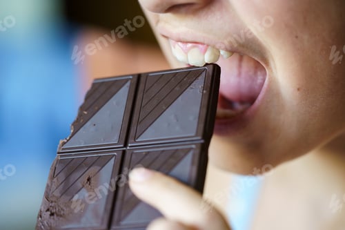 Preview: Anonymous young girl with mouth open about to eat chocolate bar