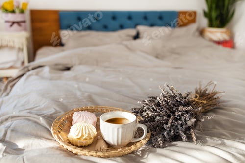 Preview: Selective focus on mug with coffee and marshmallows for breakfast in bed. Dry lavender flowers and h