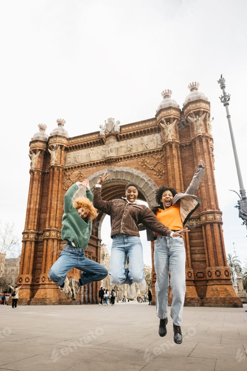 Preview: Tourists jumping at arc de triomf in barcelona, spain