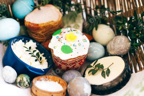 Preview: Stylish Easter eggs, easter bread cake, ham, beets, sausage, butter, green branches in wicker basket