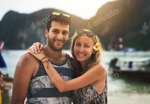 Preview: In love on the beach. Portrait of a young couple enjoying a day at the beach together.
