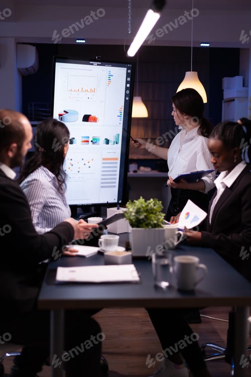Preview: Diverse multi ethnic business teamwork overworking in office meeting room analyzing financial graphs