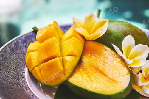 Preview: Fresh mango on a wooden tabel with tropical background. Soft focus.