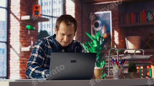 Preview: Man celebrating after receiving good news, looking at notebook