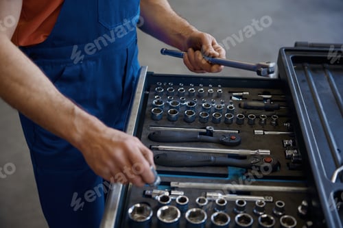 Preview: Closeup high angle view on tool box and male mechanic hands taking wrench