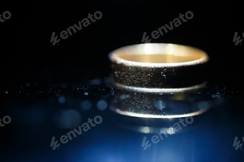Preview: Gold wedding ring on black glass